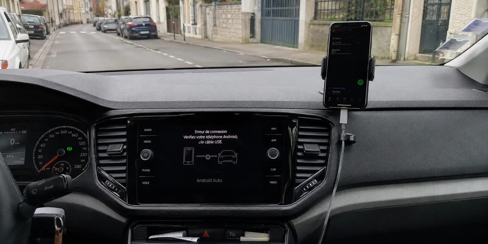 L’écran de la voiture affiche une erreur de connexion Android Auto tandis que le téléphone est monté sur le tableau de bord