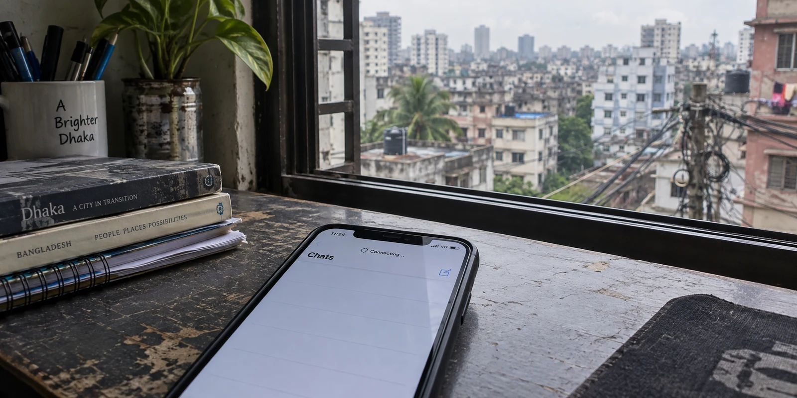 A messaging app stuck connecting beside a window overlooking Dhaka.