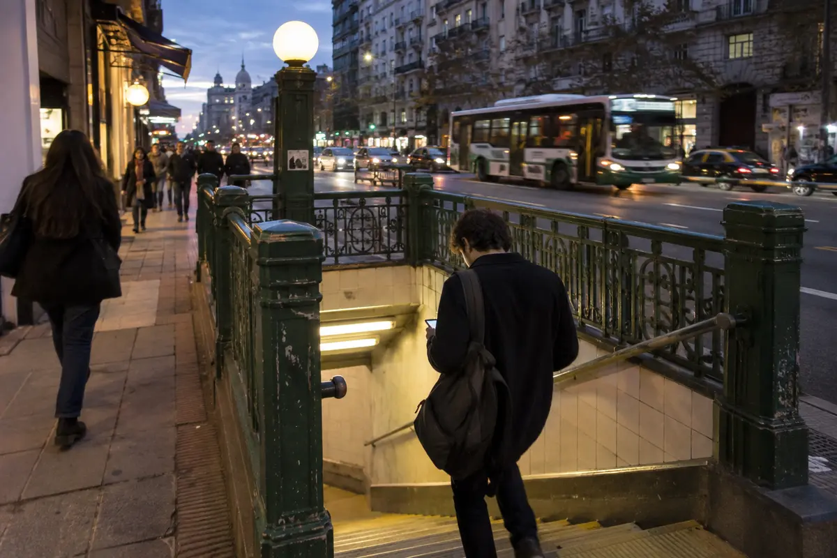 A commuter checks a phone while entering a Buenos Aires Subte station
