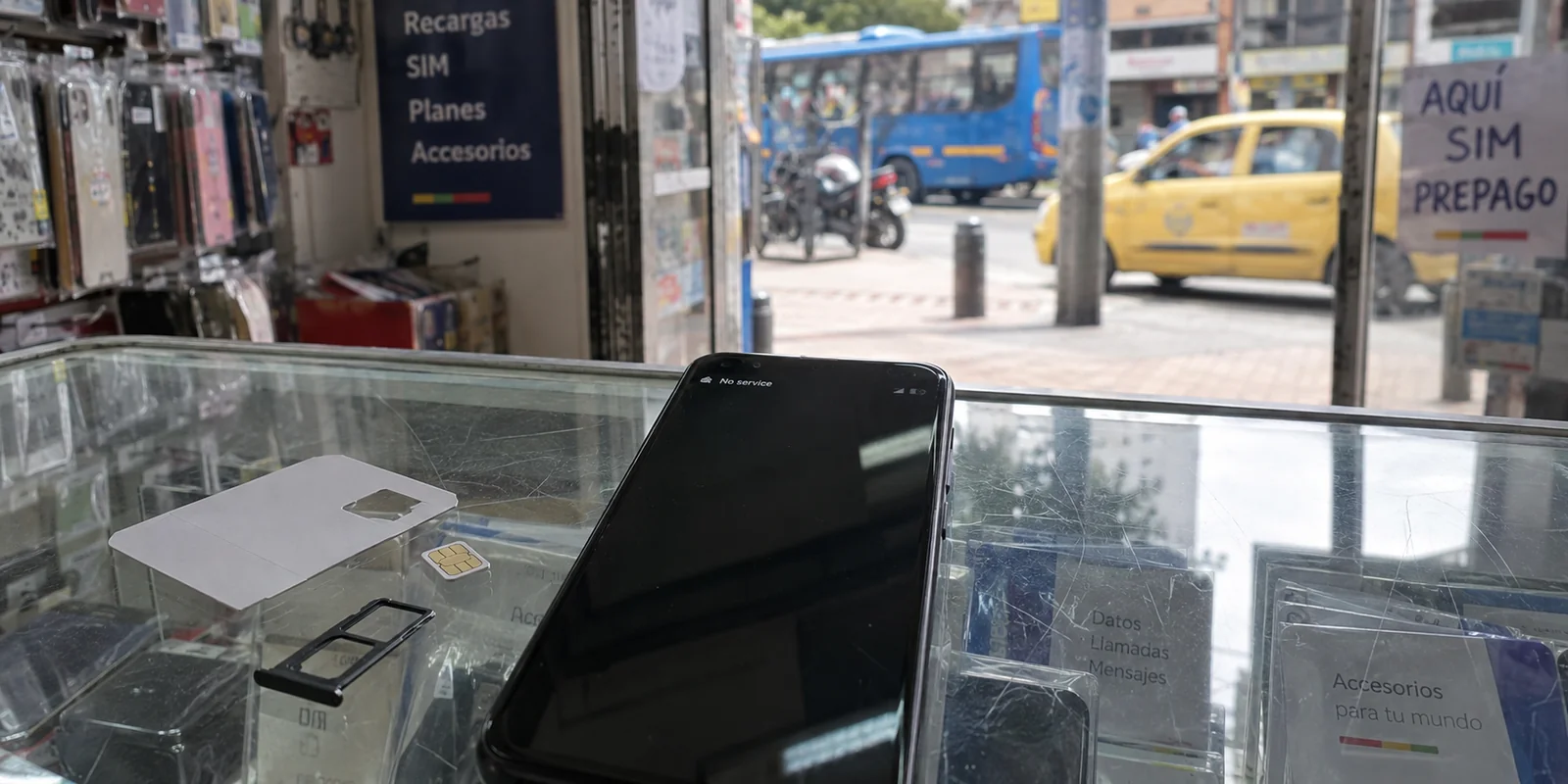 A phone with no service beside a new local SIM in a Colombian mobile shop