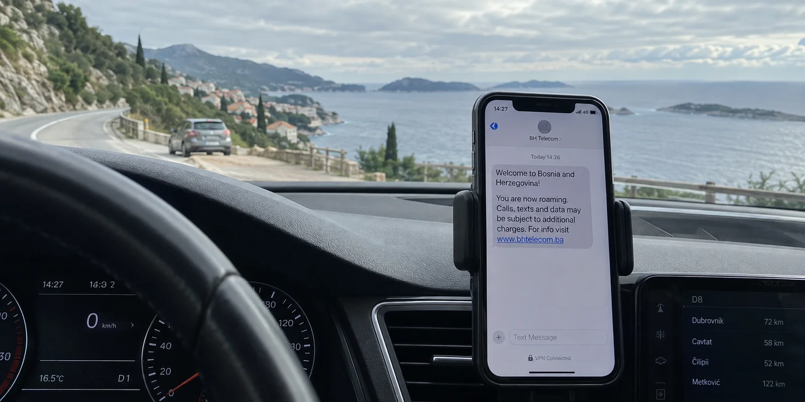 A roaming SMS from Bosnia appears on a phone while parked on a Croatian coastal road