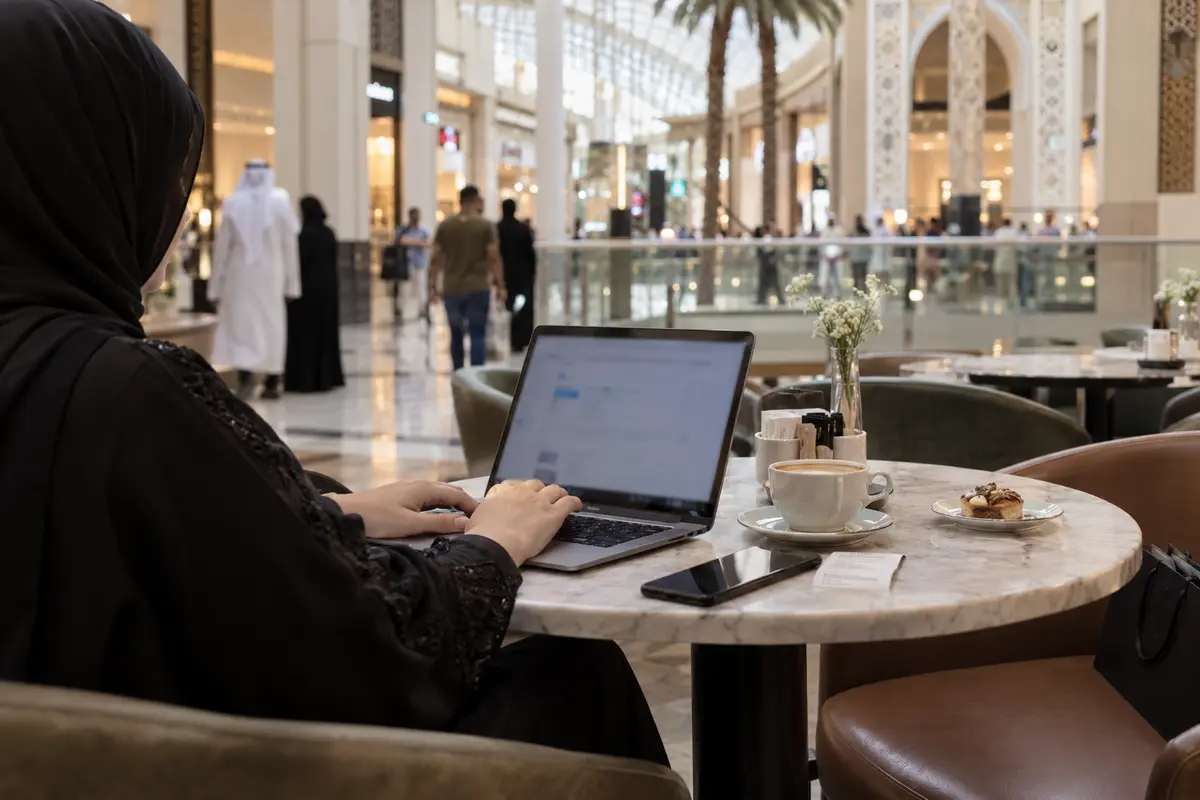 A laptop is used for an ordinary work session on public Wi-Fi in a Kuwait City mall café