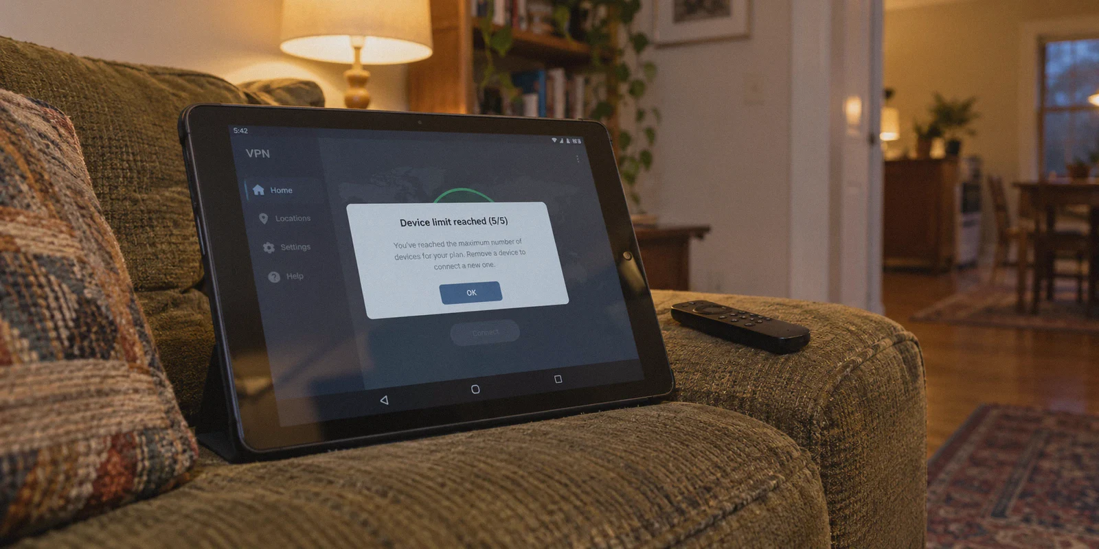 Tablet displaying a device-limit message on a sofa arm.