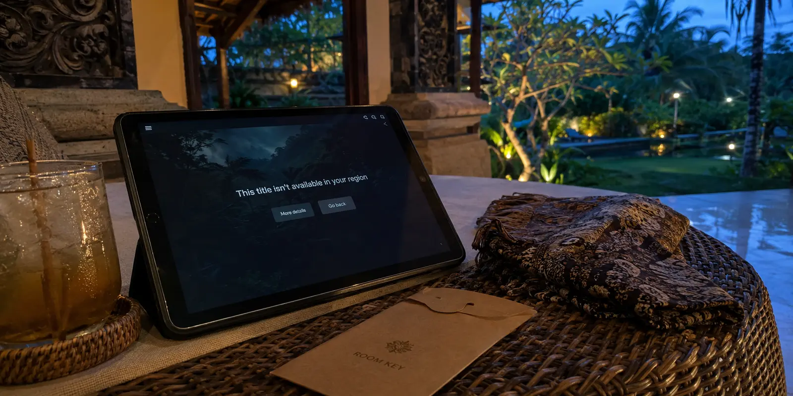 Tablet on a Bali hotel terrace showing a title unavailable in the current region