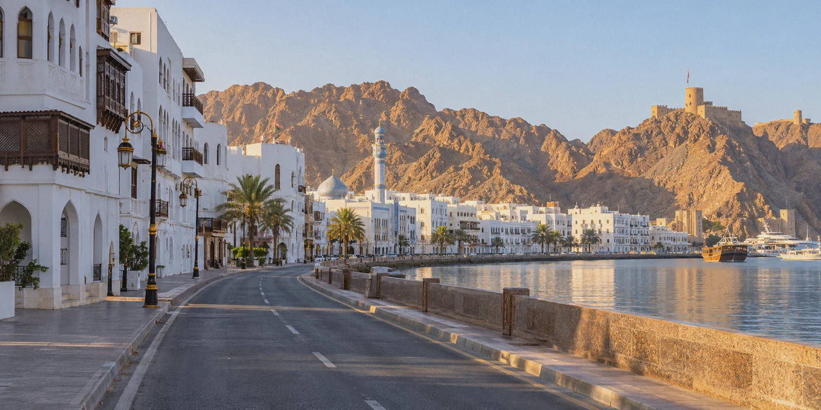 Mutrah waterfront buildings beneath the rocky hills of Muscat.