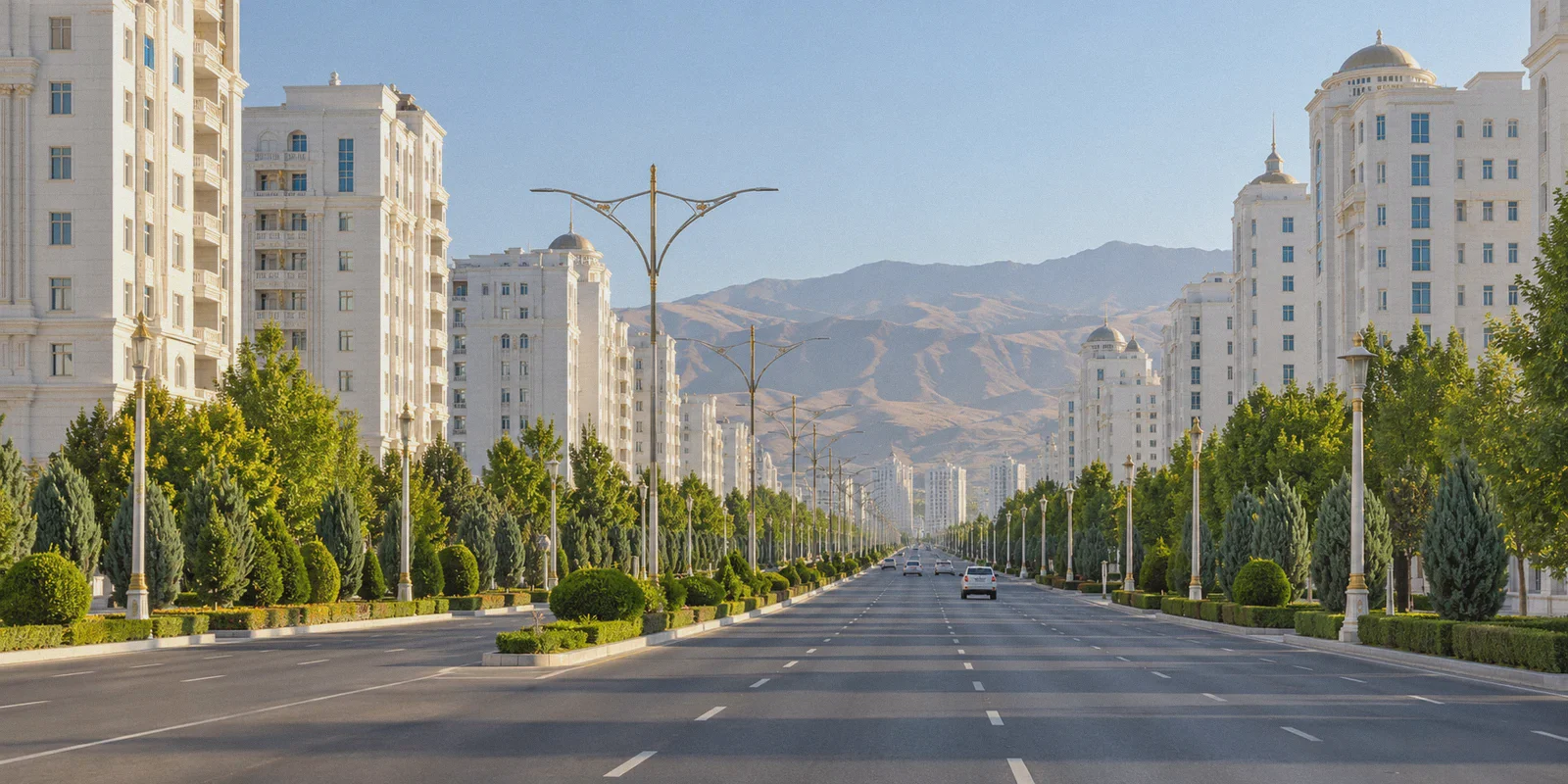 White marble residential buildings along an Ashgabat avenue.