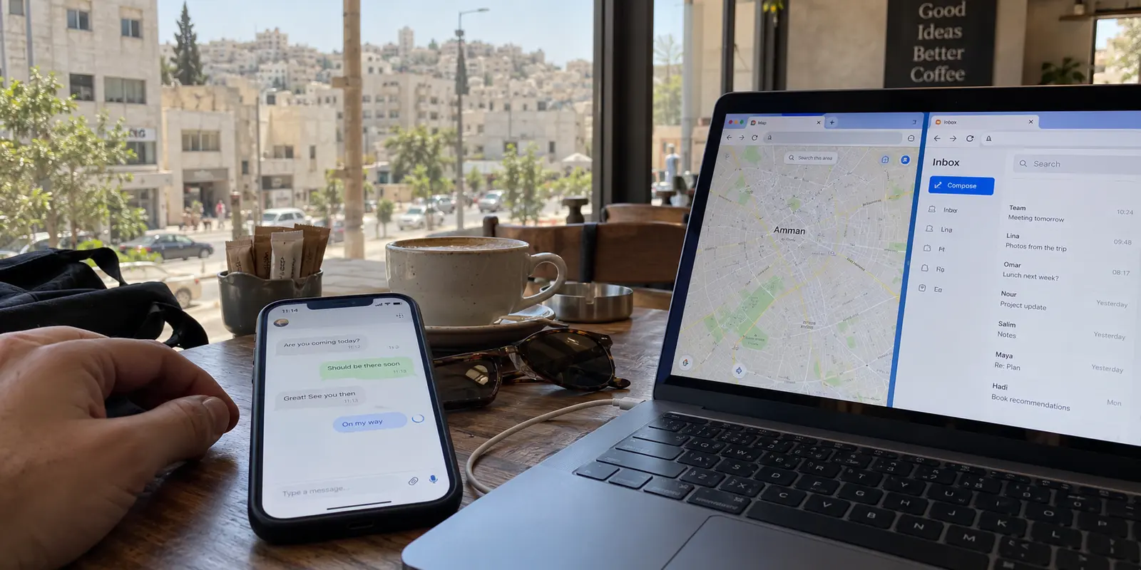 A chat message stalls on a phone in an Amman café while maps and email remain available on the laptop.