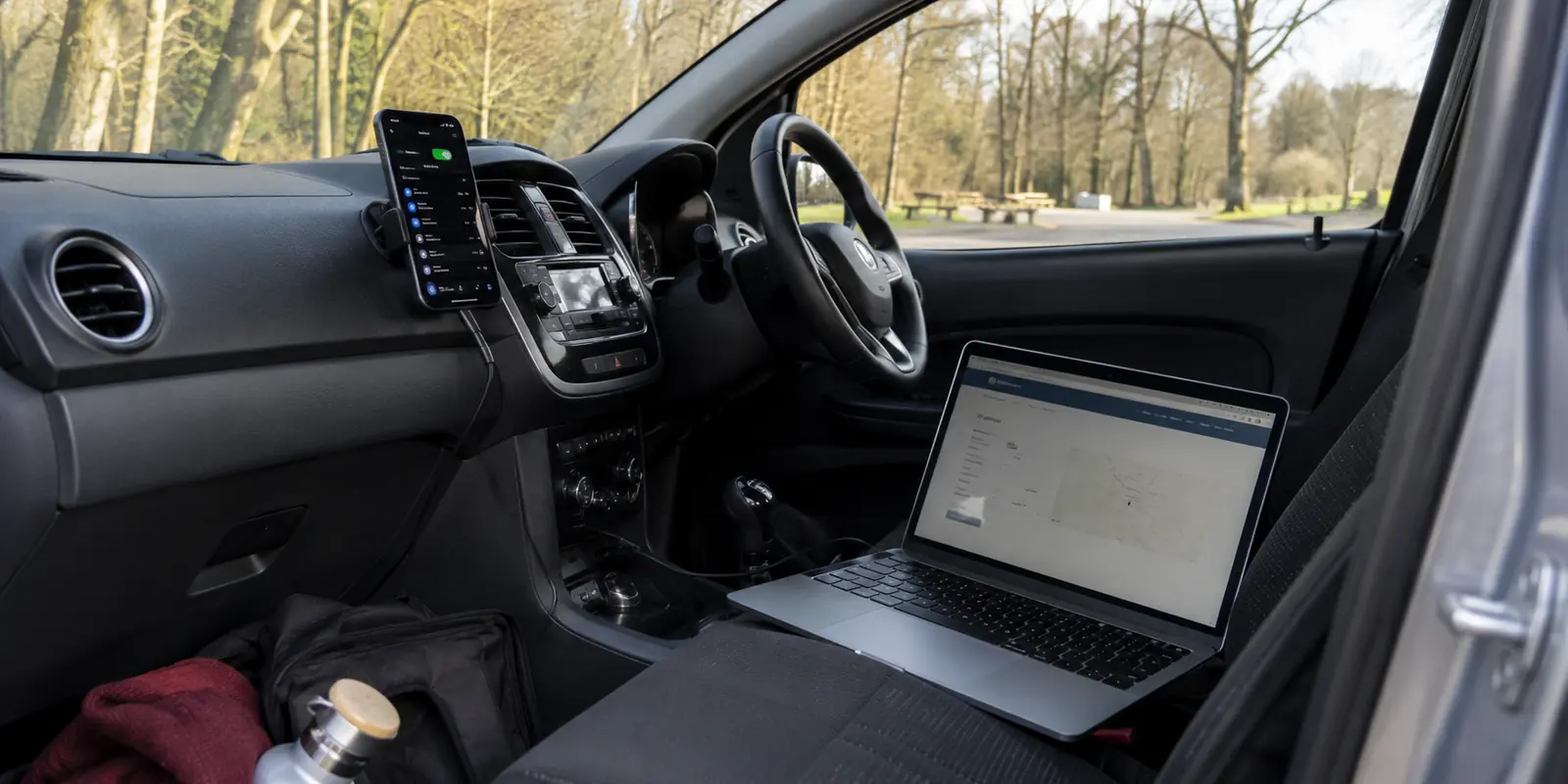 Ein Smartphone stellt im geparkten Auto einen Hotspot bereit, während der Laptop weiterhin die Mobilfunkadresse zeigt