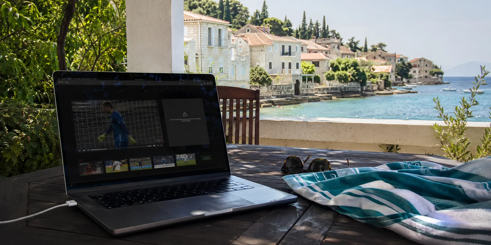 Laptop mit gesperrtem Sportstream auf einer kroatischen Küstenterrasse