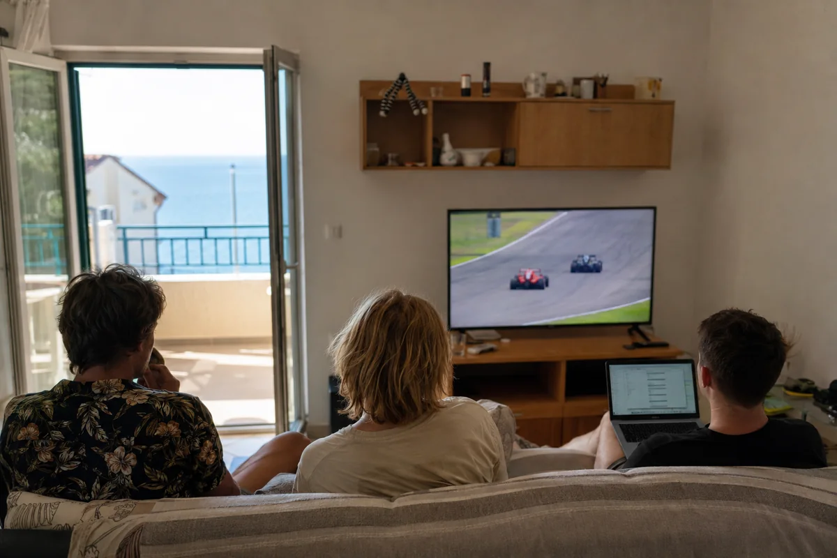 Eine Urlaubsgesellschaft verfolgt den gestarteten Rennstream im Apartment am Meer
