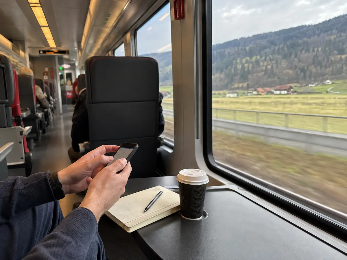 Smartphone-Nutzung während einer Zugfahrt durch die österreichische Landschaft
