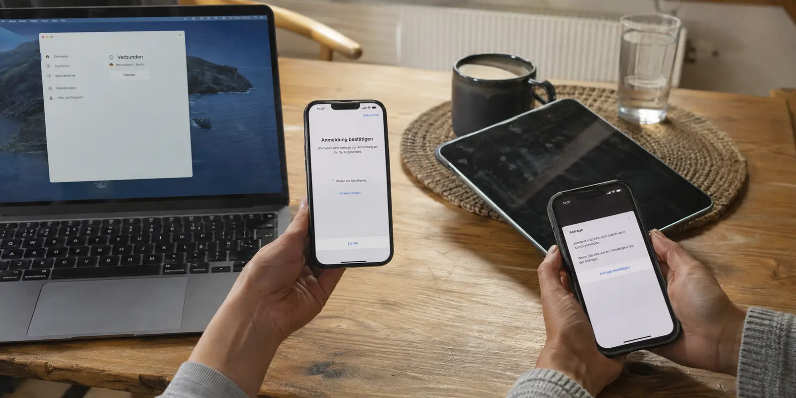 Ein zweites Smartphone wartet auf die Anmeldebestätigung, während Laptop und Tablet ebenfalls eingerichtet werden sollen