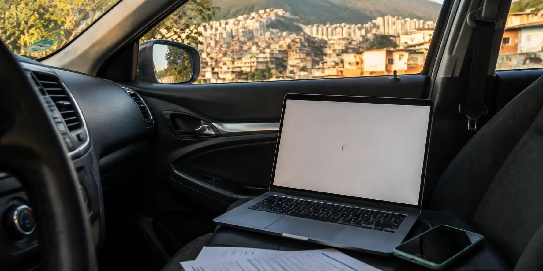 Un portátil intenta reconectarse dentro de un carro mientras Medellín aparece al fondo