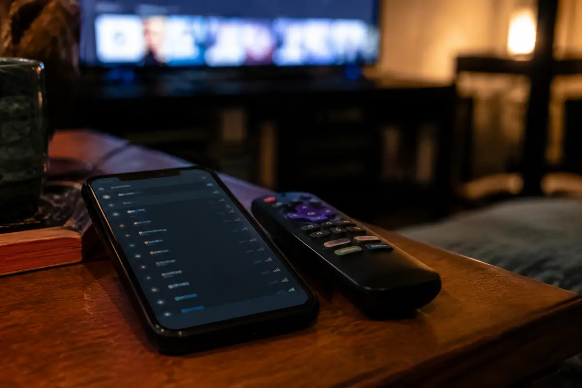 Teléfono con una lista de servidores VPN junto al mando del televisor