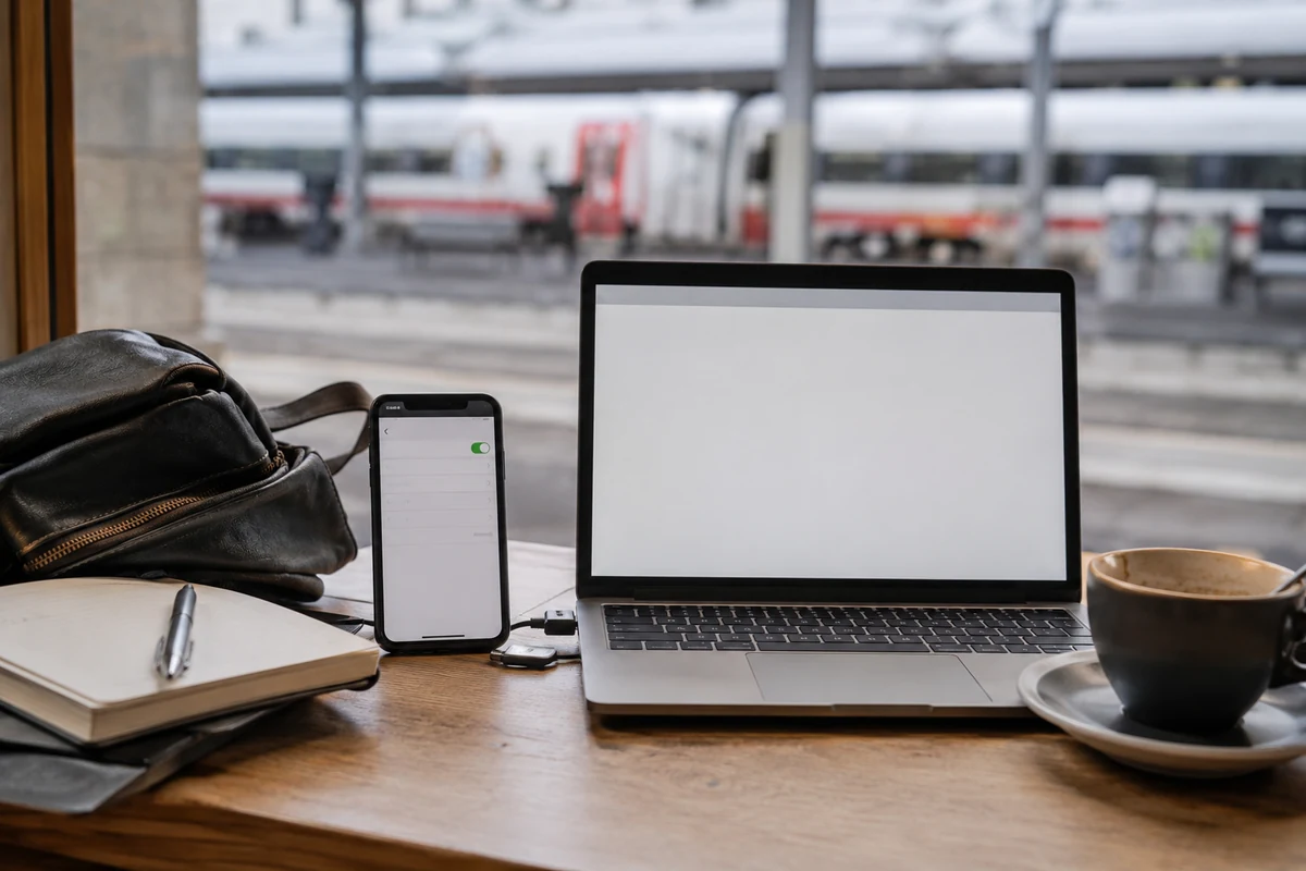 Laptop und Smartphone mit aktivem mobilen Datenzugang an einem Bahnhofscafé