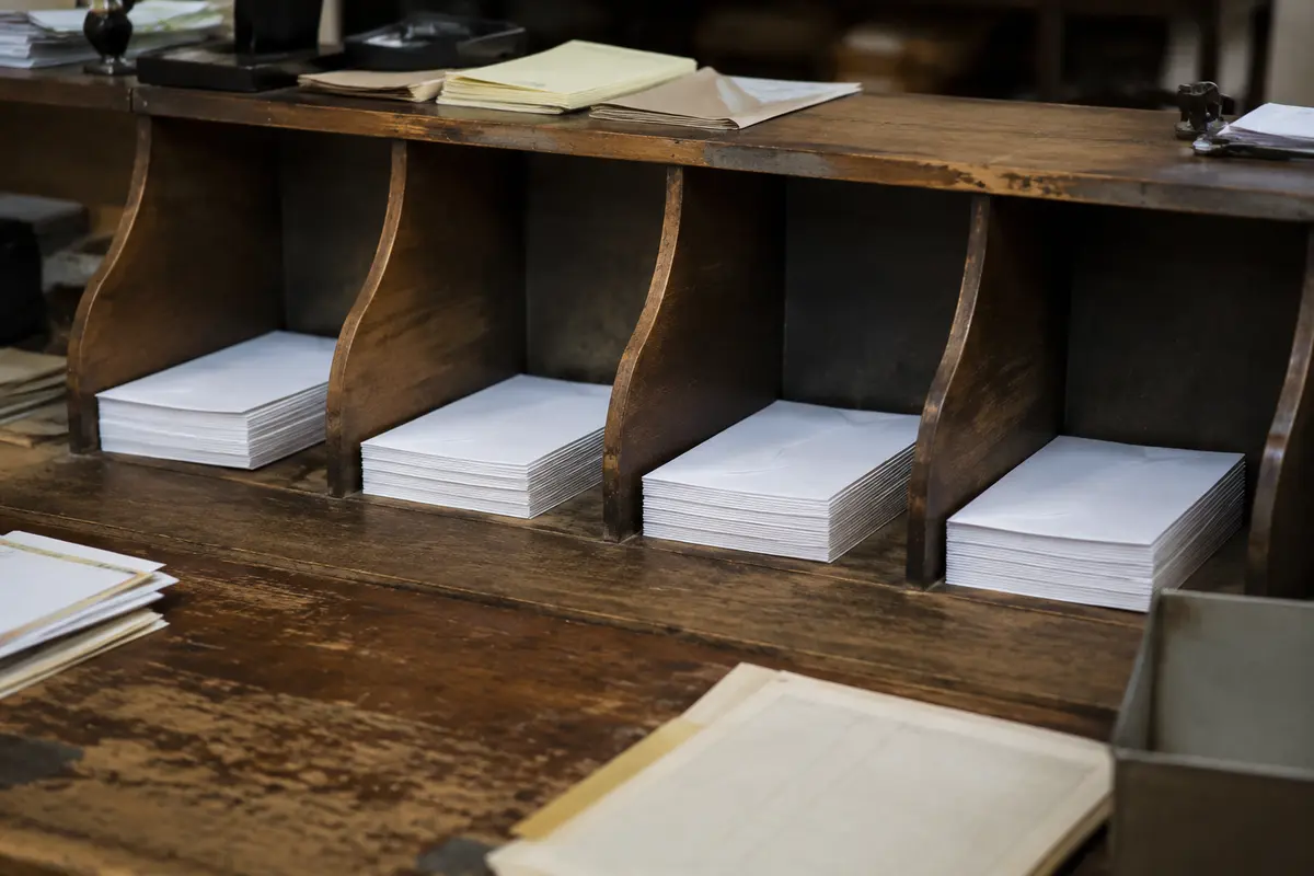 Des enveloppes identiques sont réparties entre plusieurs casiers de tri