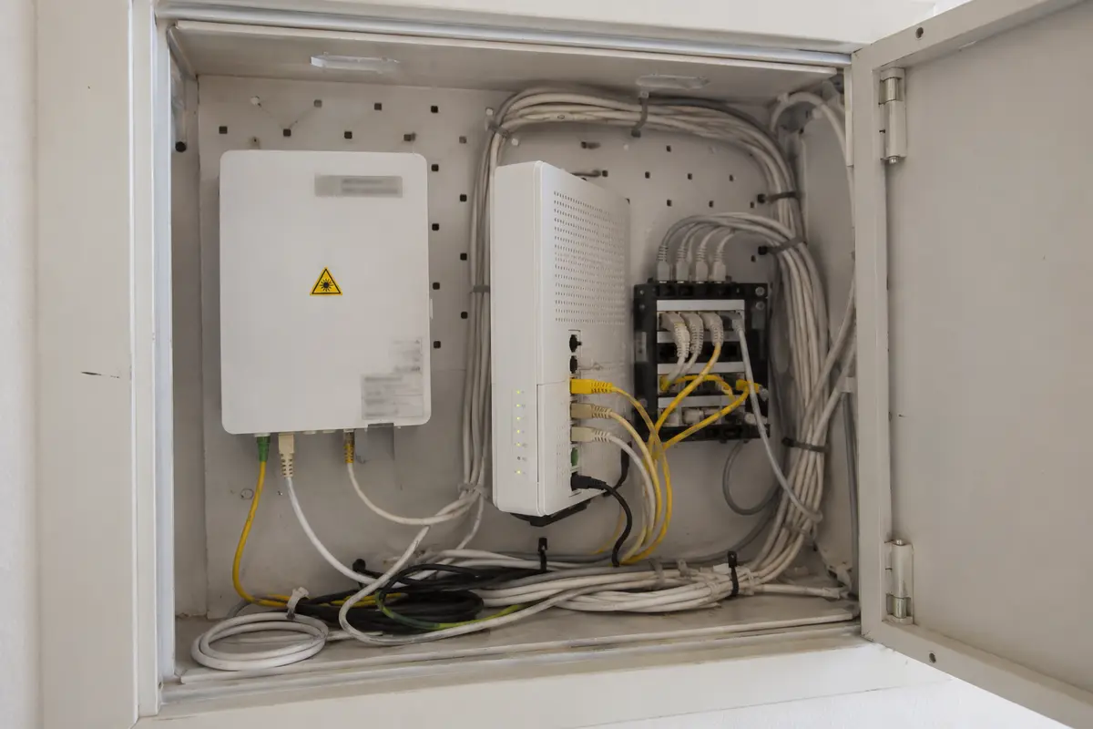Glasfaserabschluss, Modem und Verkabelung in einem Schweizer Wohnungsverteiler
