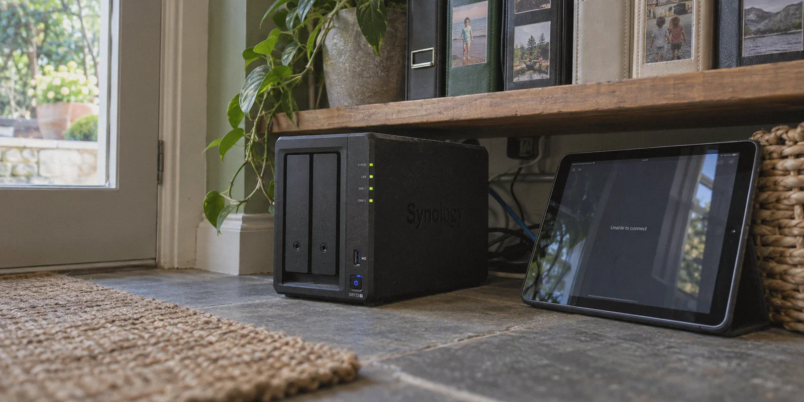 A home NAS beside a tablet showing a remote-access failure.