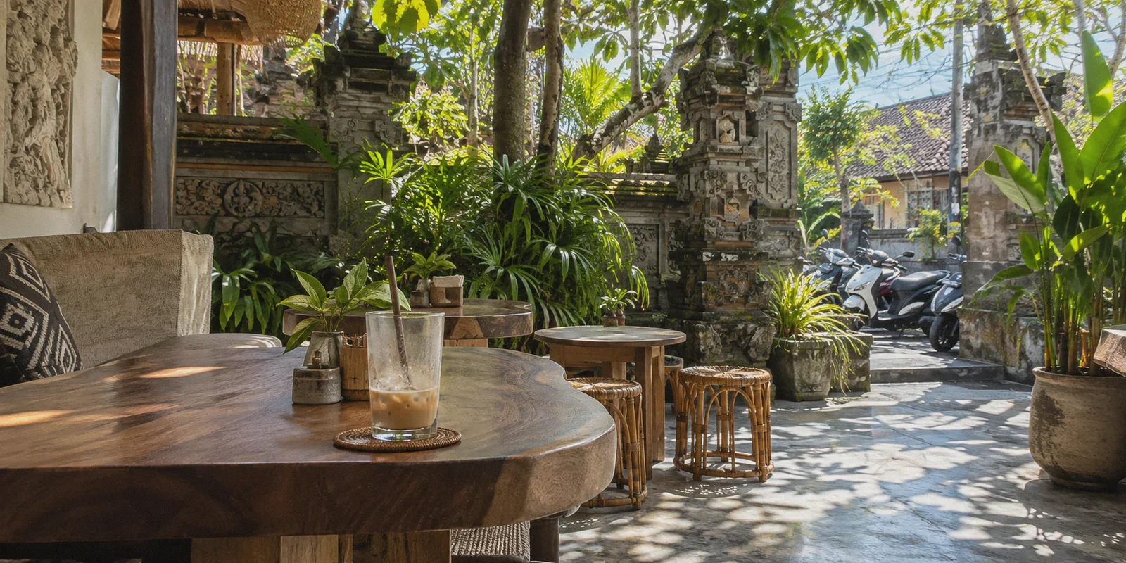 A shaded Canggu cafe terrace with carved stone garden walls.