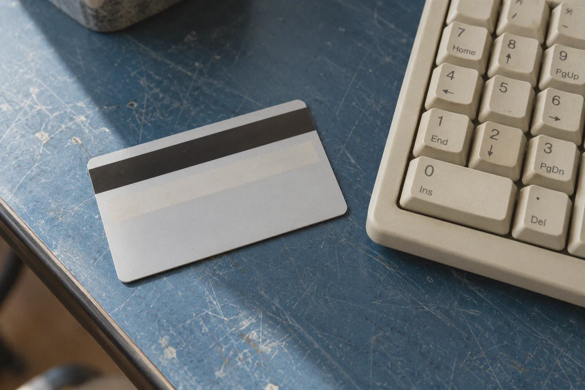 A bank card beside a desktop keyboard.