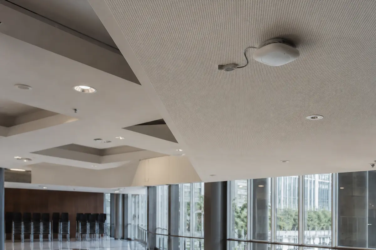 Un point d’accès Wi-Fi fixé au plafond d’un centre de conférences rappelle que chaque réseau possède sa propre infrastructure.