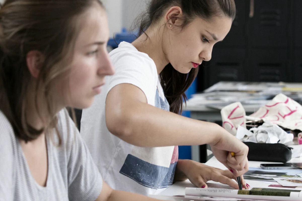Students sorting papers and materials at a worktable.