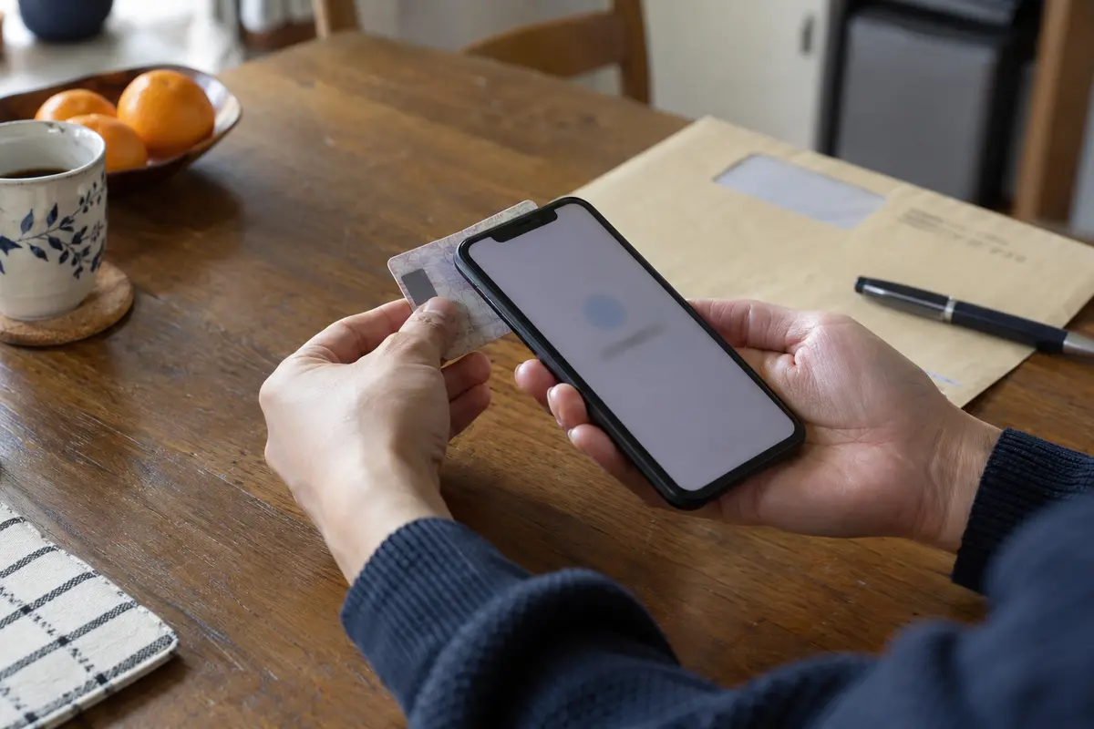 A physical identity card being tested with an NFC-enabled smartphone before departure