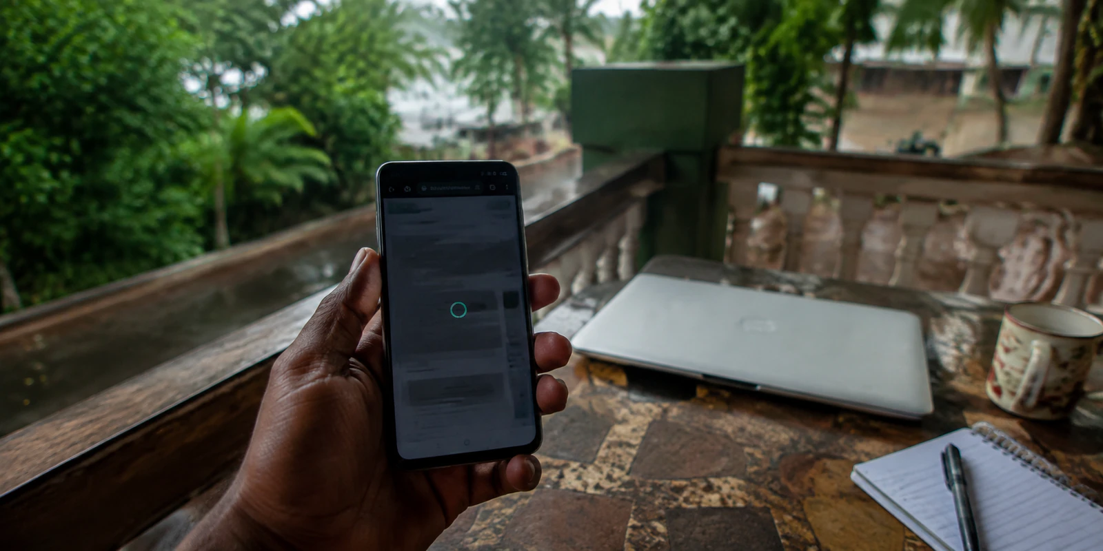 Un teléfono muestra una página detenida en una terraza de Malabo después de la lluvia
