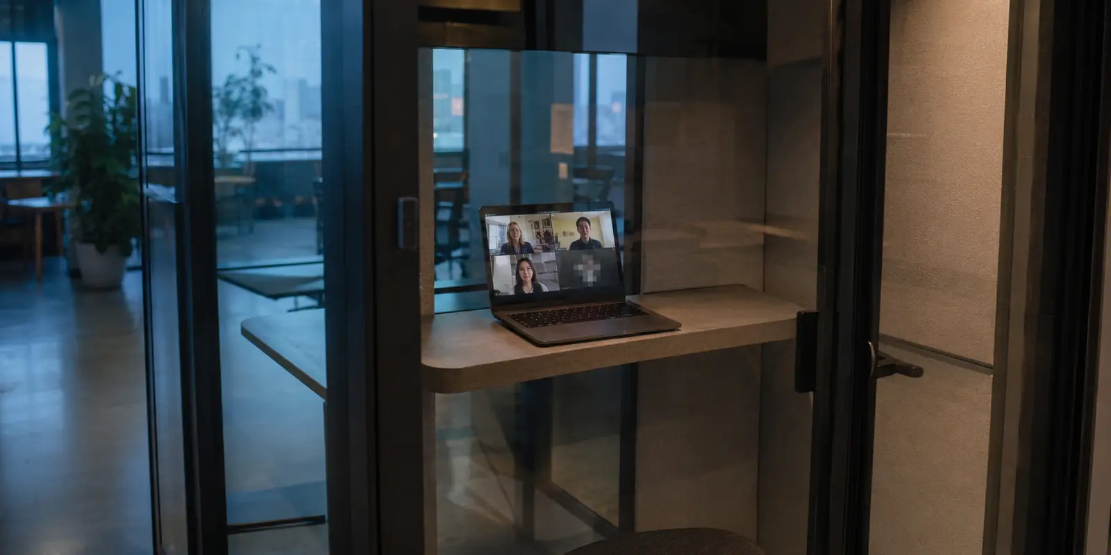 Notebook em uma cabine de coworking durante uma videochamada que começa a falhar