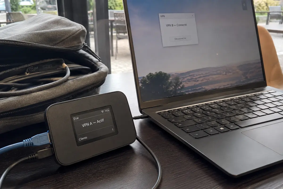 Dans un café, un routeur de voyage fait fonctionner le VPN A tandis que l’ordinateur établit séparément le VPN B.