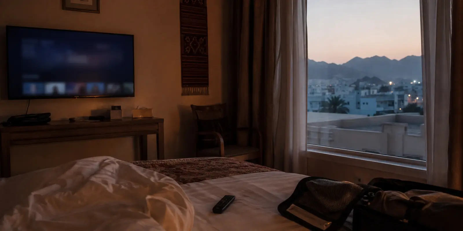 شاشة بث متوقفة في غرفة فندق بمسقط عند الغروب
