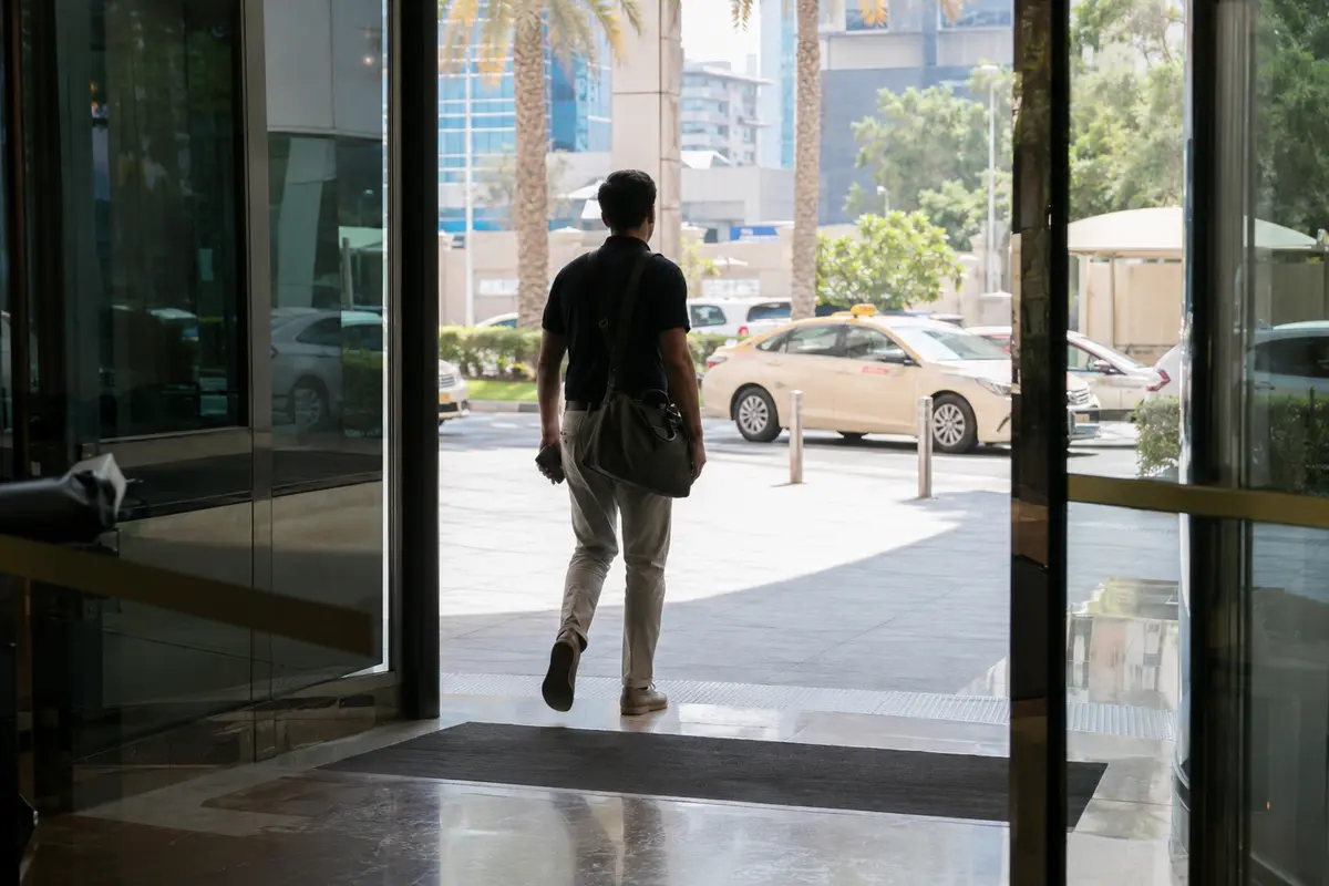 مسافر يغادر فندقًا في دبي بينما ينتقل هاتفه إلى بيانات الجوال