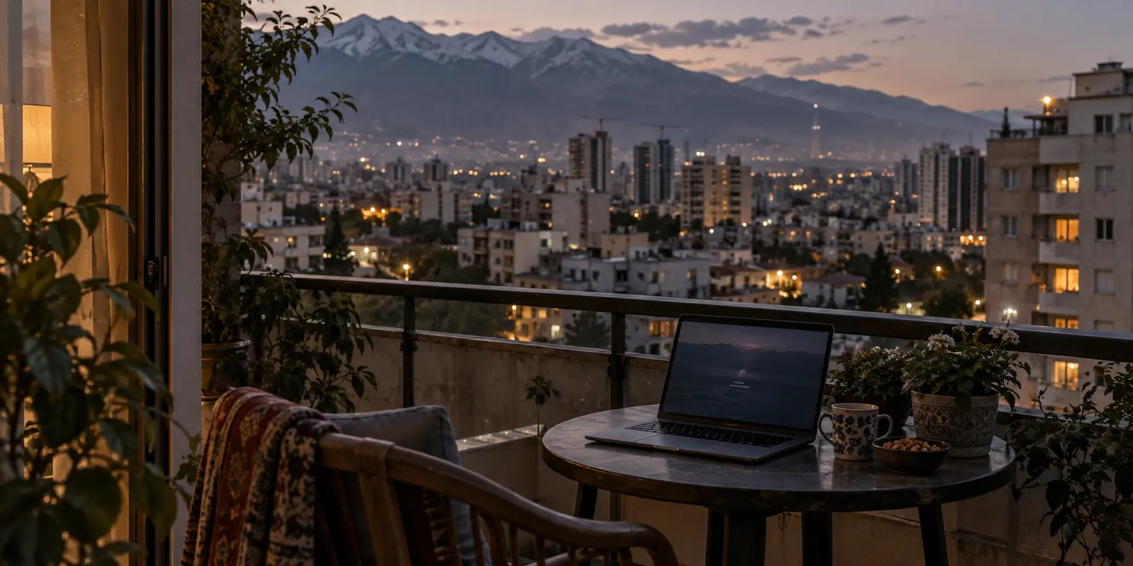 A laptop on a Tehran balcony overlooking the city at dusk