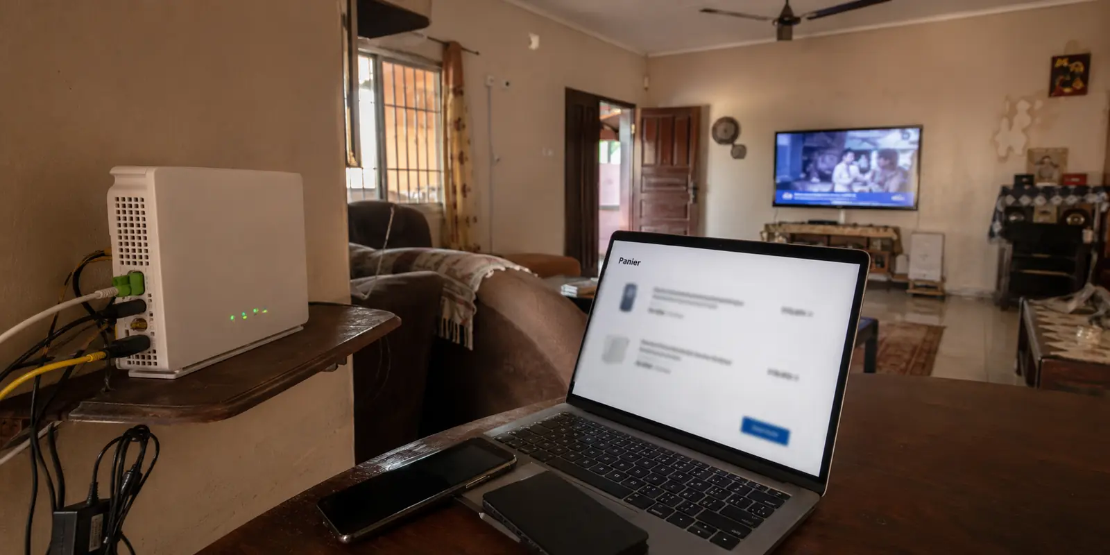 Dans une maison à Dakar, la Fiberbox fonctionne encore tandis qu’un routeur de remplacement attend déjà dans le panier en ligne.