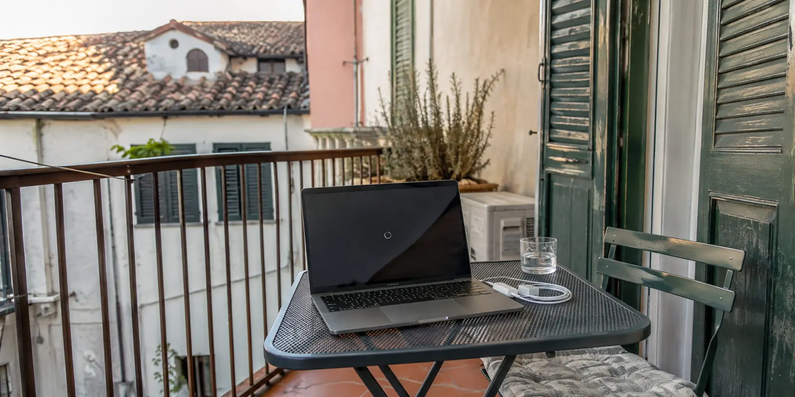 Laptop mit stockendem Videoplayer auf dem Balkon einer italienischen Ferienwohnung