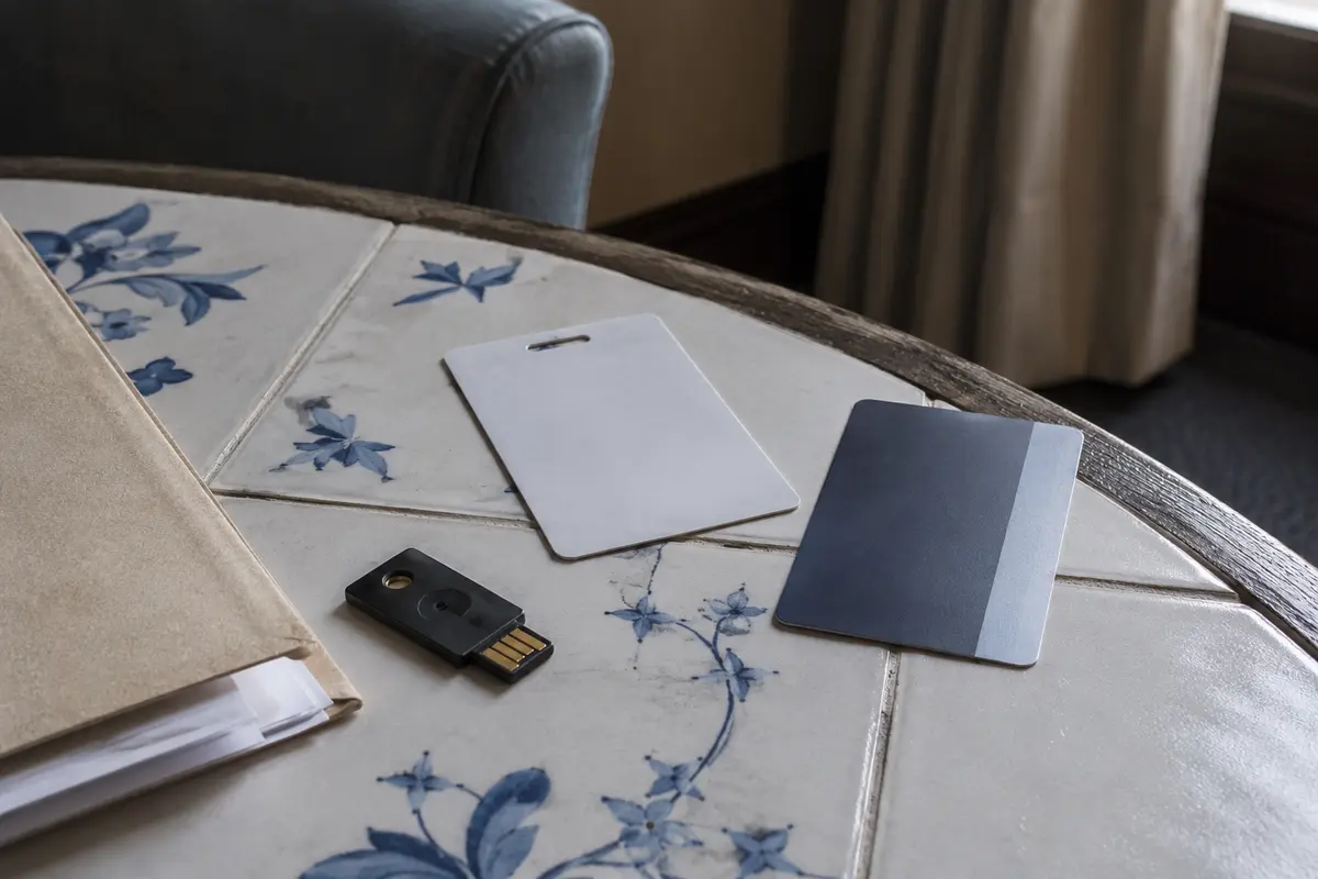 Clé de sécurité, badge professionnel et carte d’hôtel posés près d’un dossier