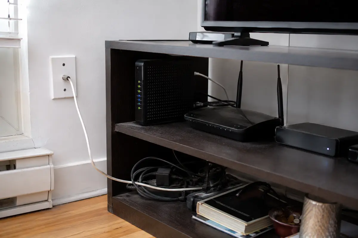 Un modem câble, un routeur et un équipement de télévision sont reliés à la ligne résidentielle d’un appartement.