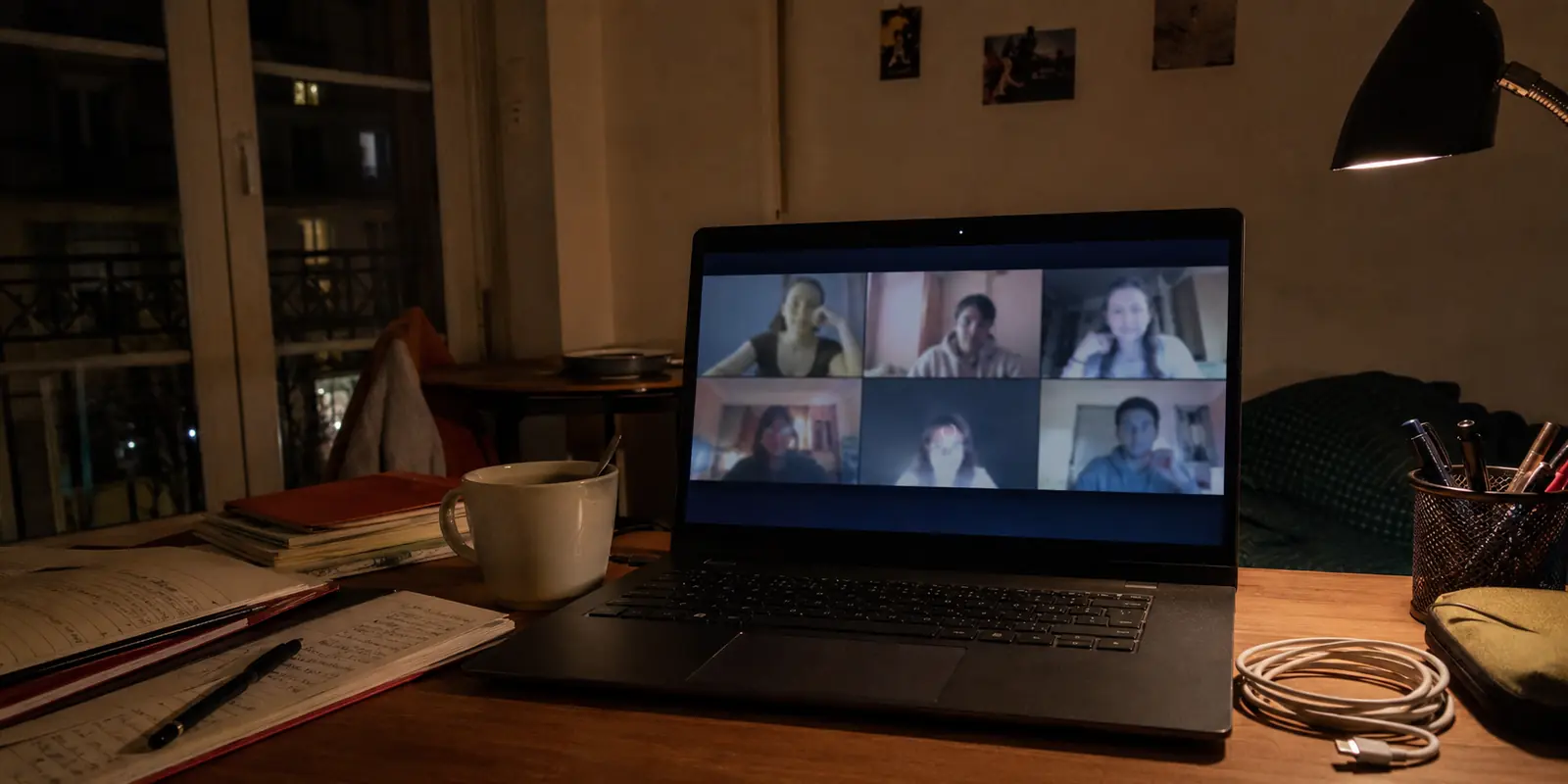 Visioconférence figée sur un ordinateur dans une chambre étudiante le soir