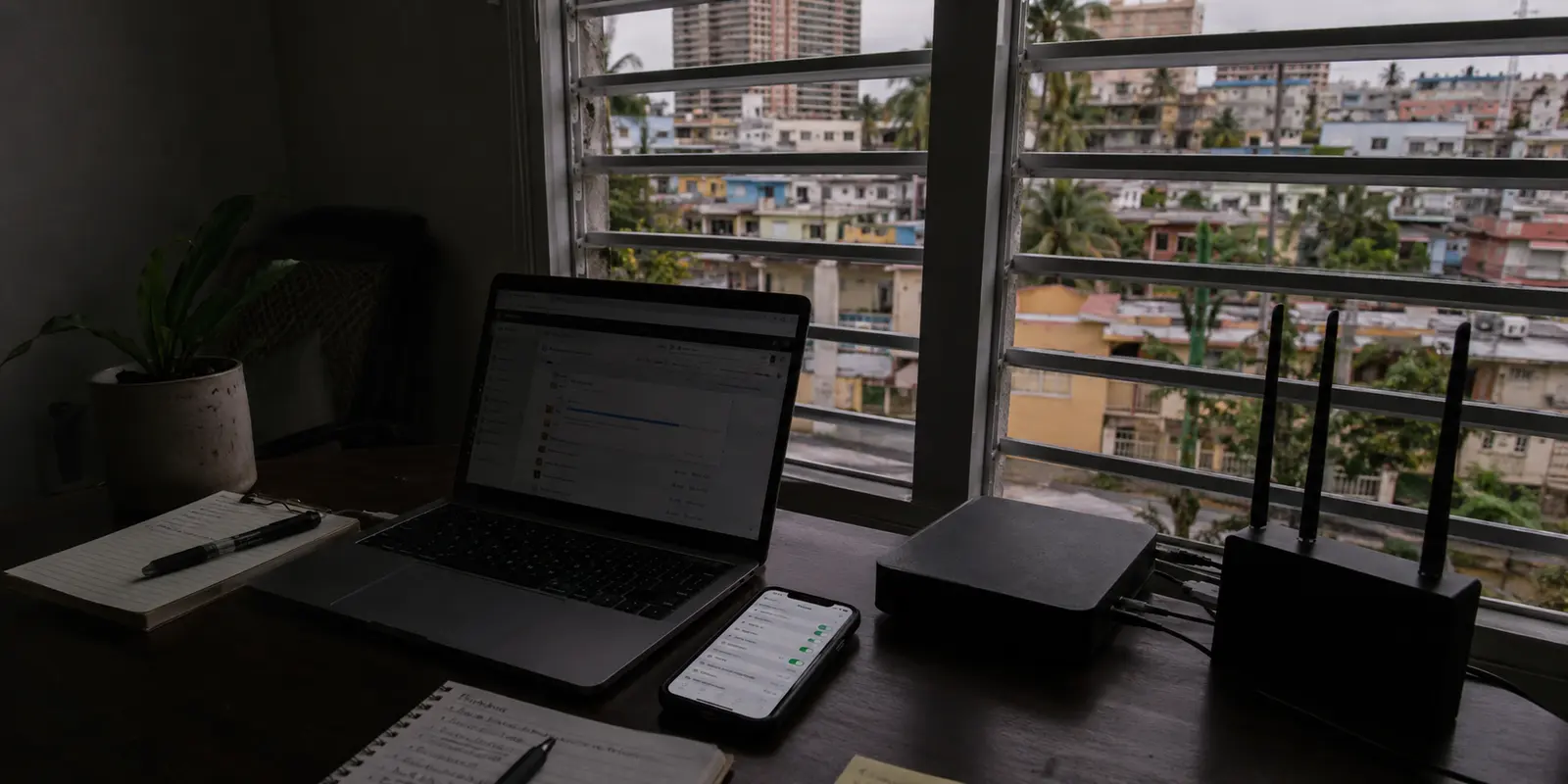 Oficina doméstica en San Juan durante un apagón, con la fibra apagada y un teléfono usado como hotspot
