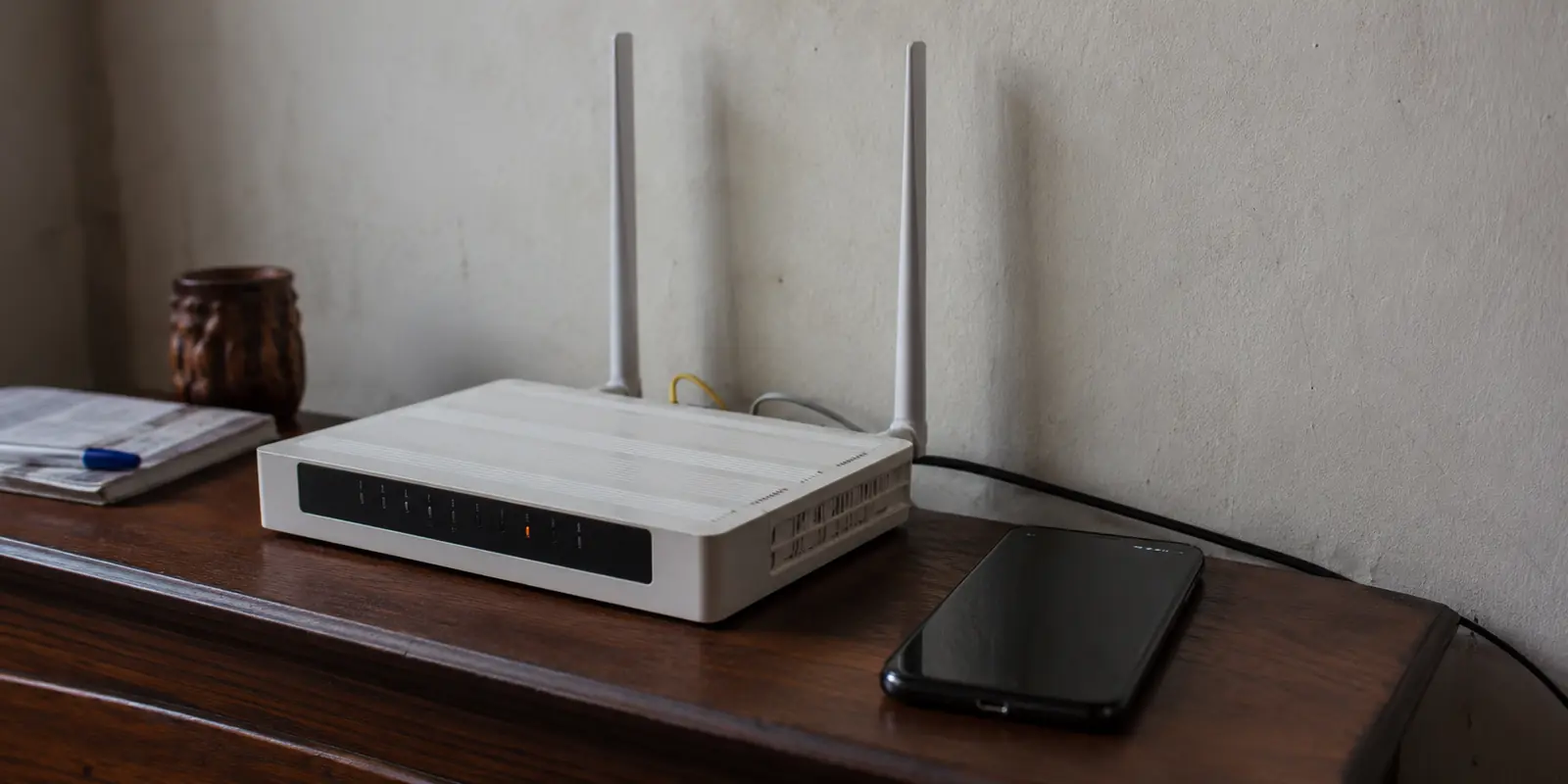 Roteador doméstico em Luanda com falha de conexão e telefone sem acesso à rede ao lado