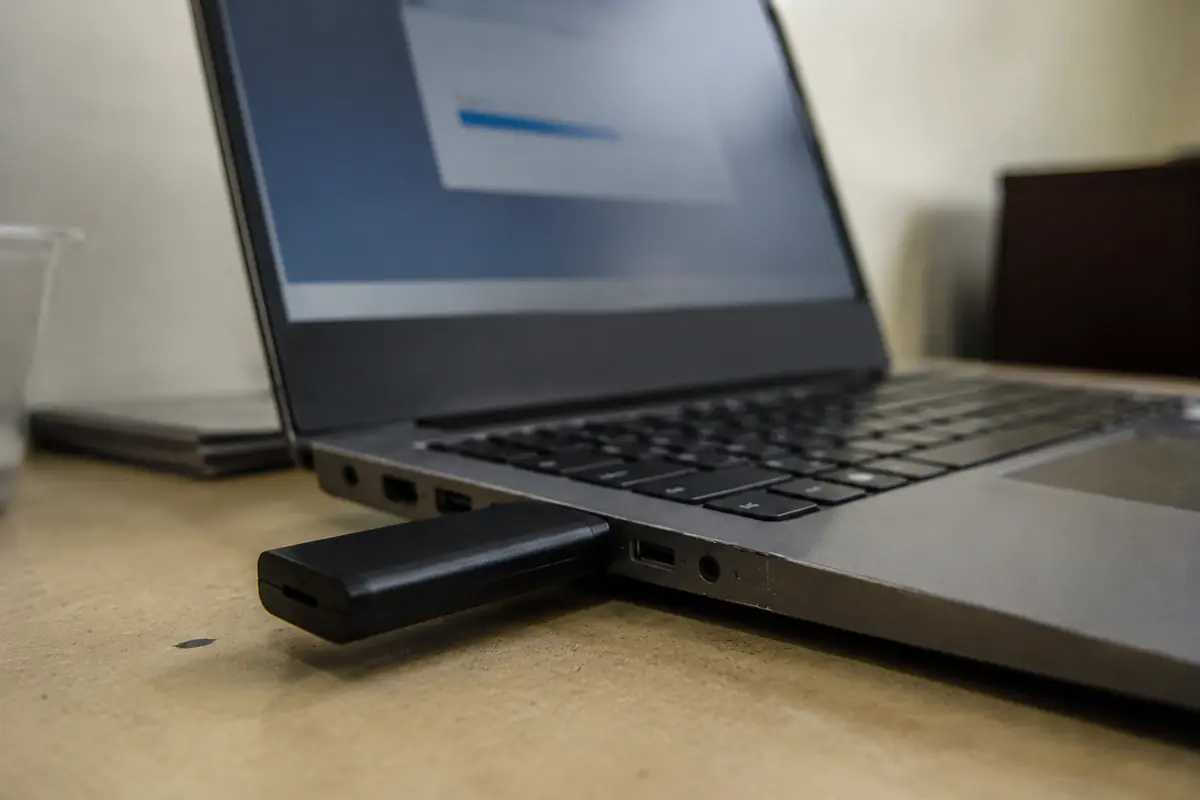 Modem celular USB conectado a um notebook durante o envio de um arquivo