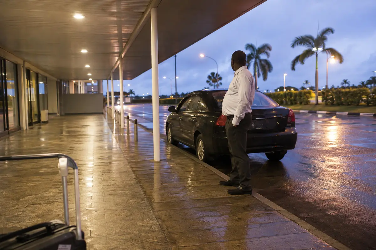 Motorista aguardando um viajante na área de desembarque do aeroporto de Malabo