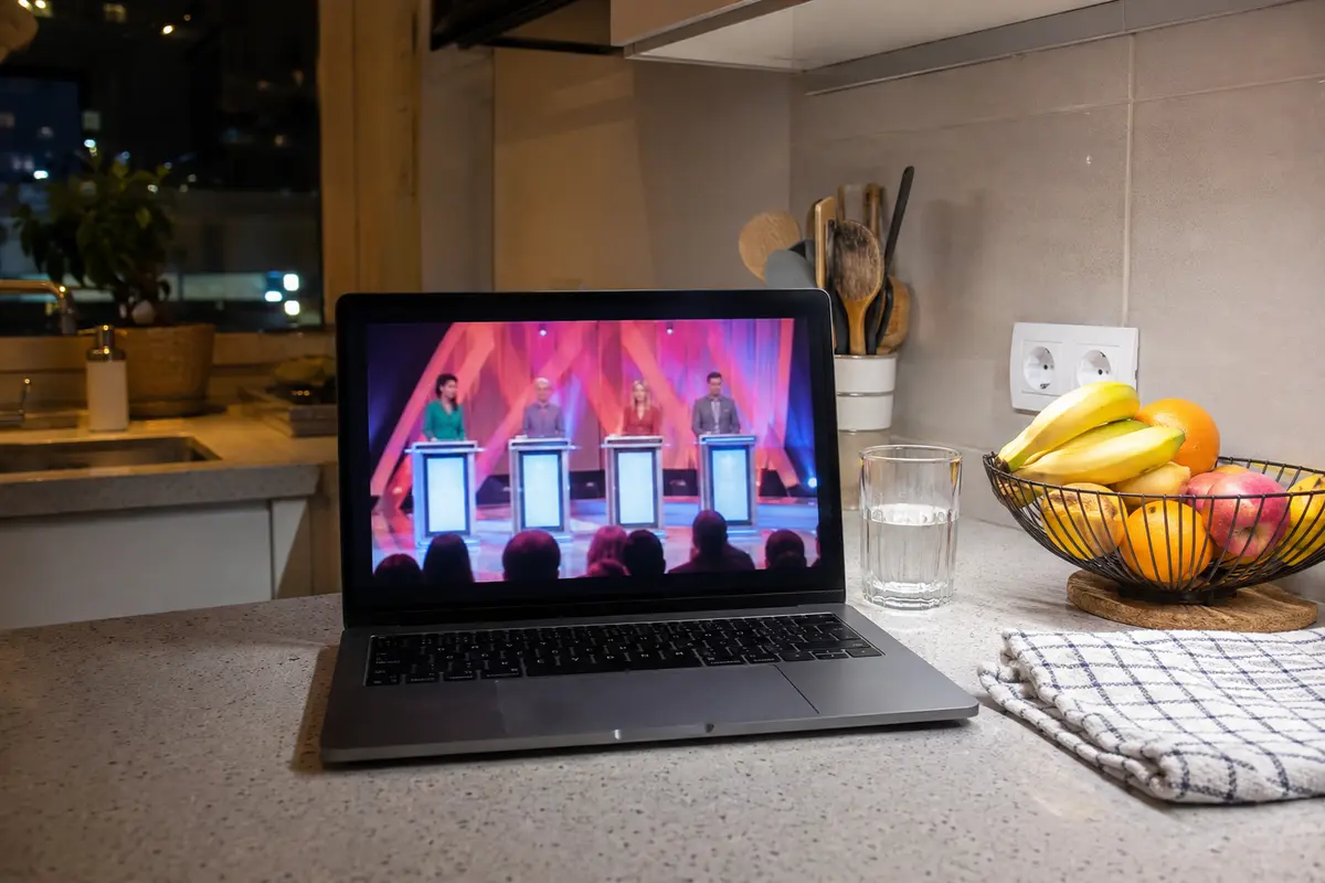 Programa de entretenimento português a reproduzir num portátil levado para a cozinha