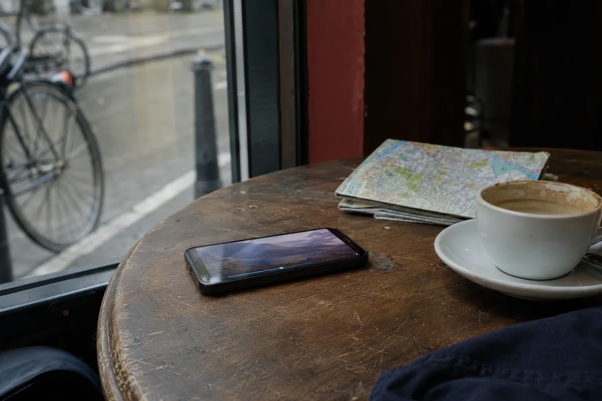 Telefone reproduzindo um vídeo sem interrupções sobre uma mesa de café durante uma viagem.