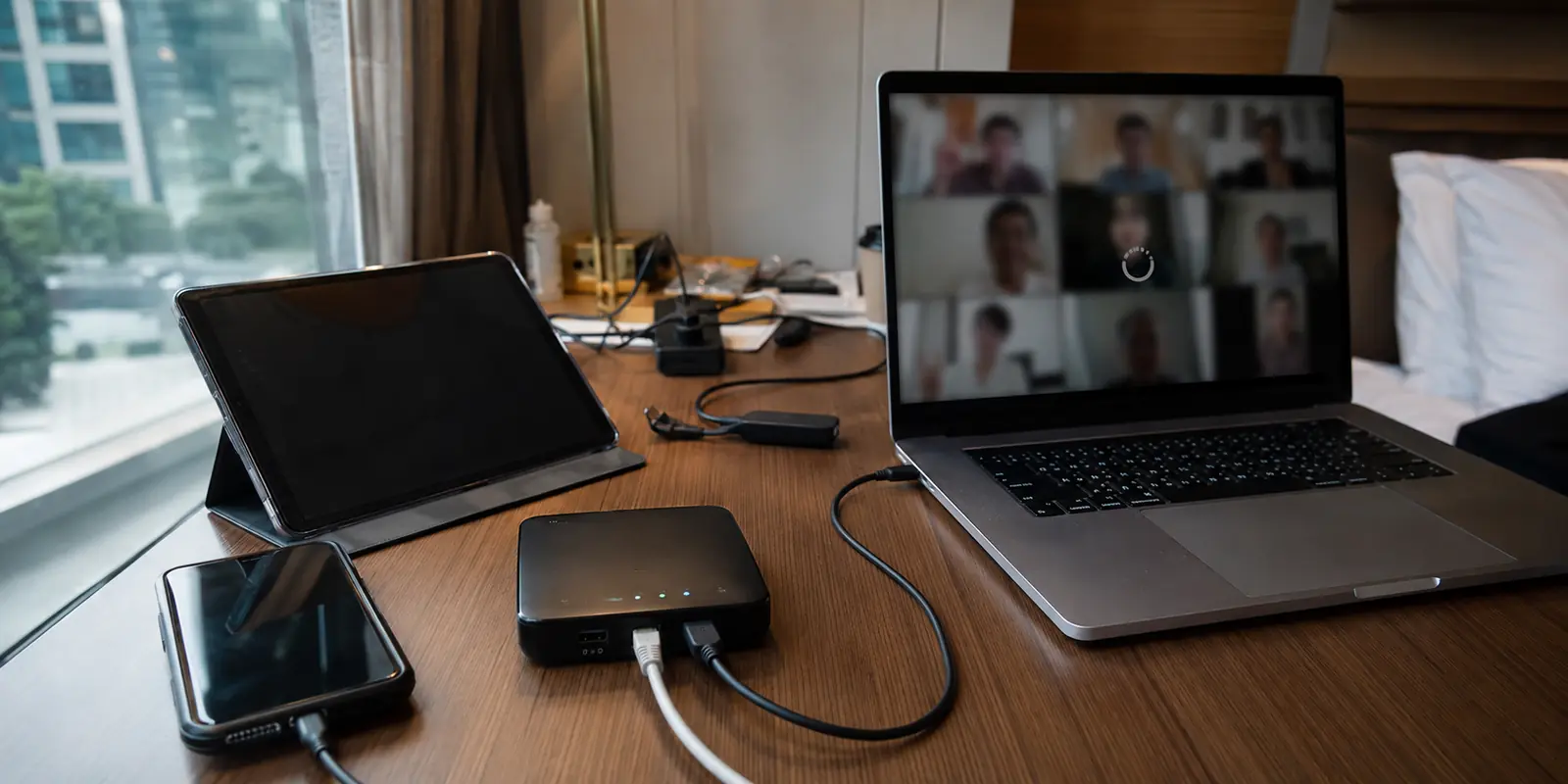 Un router de viaje sigue encendido mientras una videollamada queda detenida en un hotel de Bangkok.