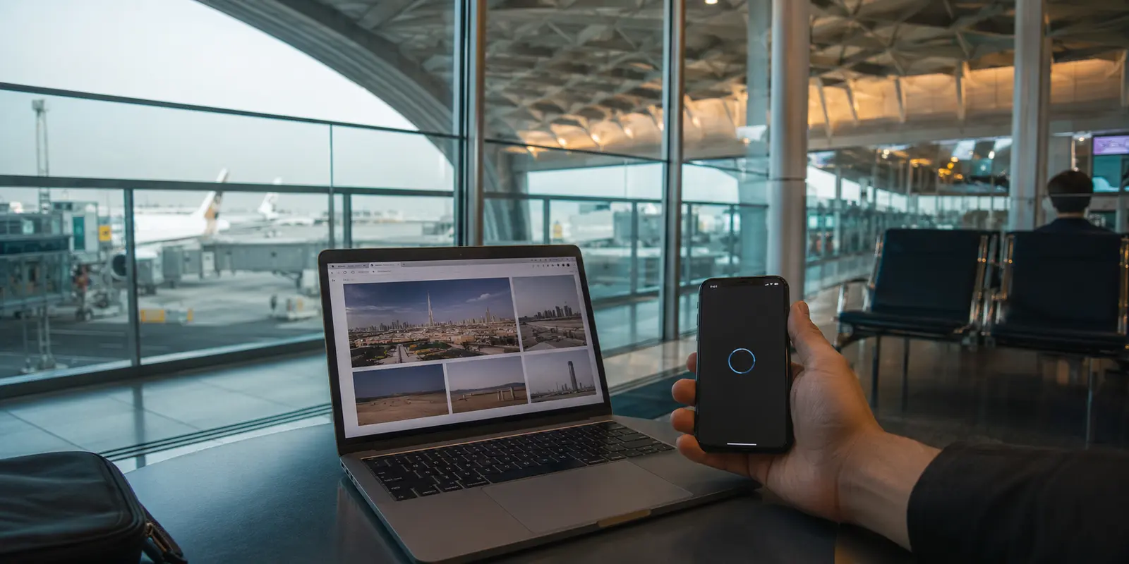 Portátil con internet y móvil esperando la conexión VPN en una puerta de embarque de Emiratos Árabes Unidos