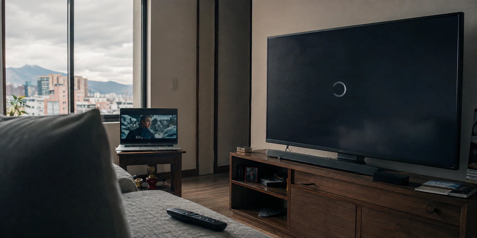 Una película funciona en el portátil mientras el televisor con Fire TV permanece cargando en una sala de Bogotá