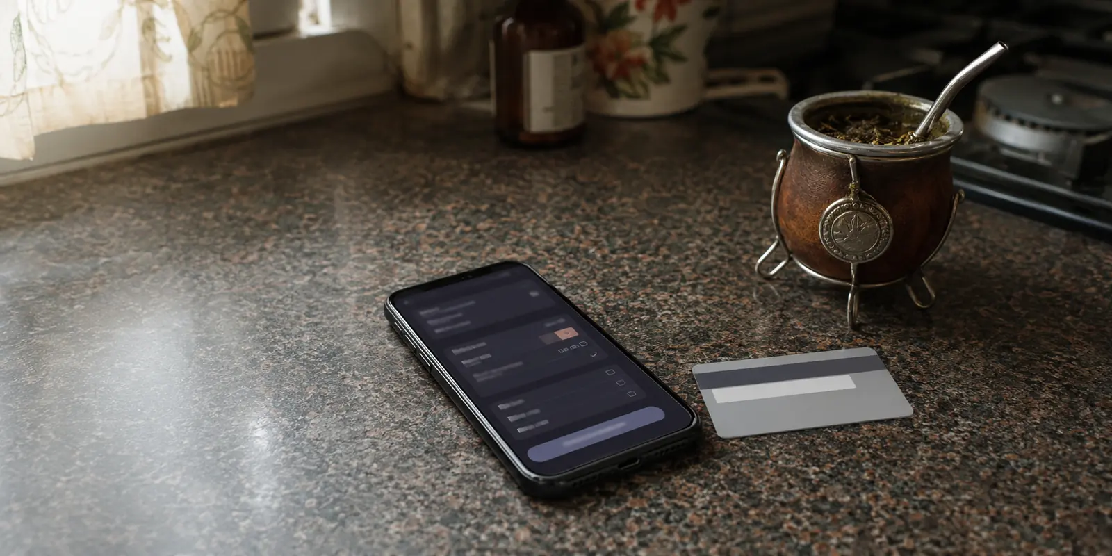 Teléfono con una pantalla de pago junto a una tarjeta y un mate antes de contratar una VPN