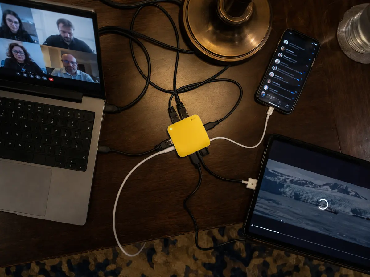 Un pequeño router concentra una videollamada, mensajes y vídeo de tres dispositivos en la misma mesa