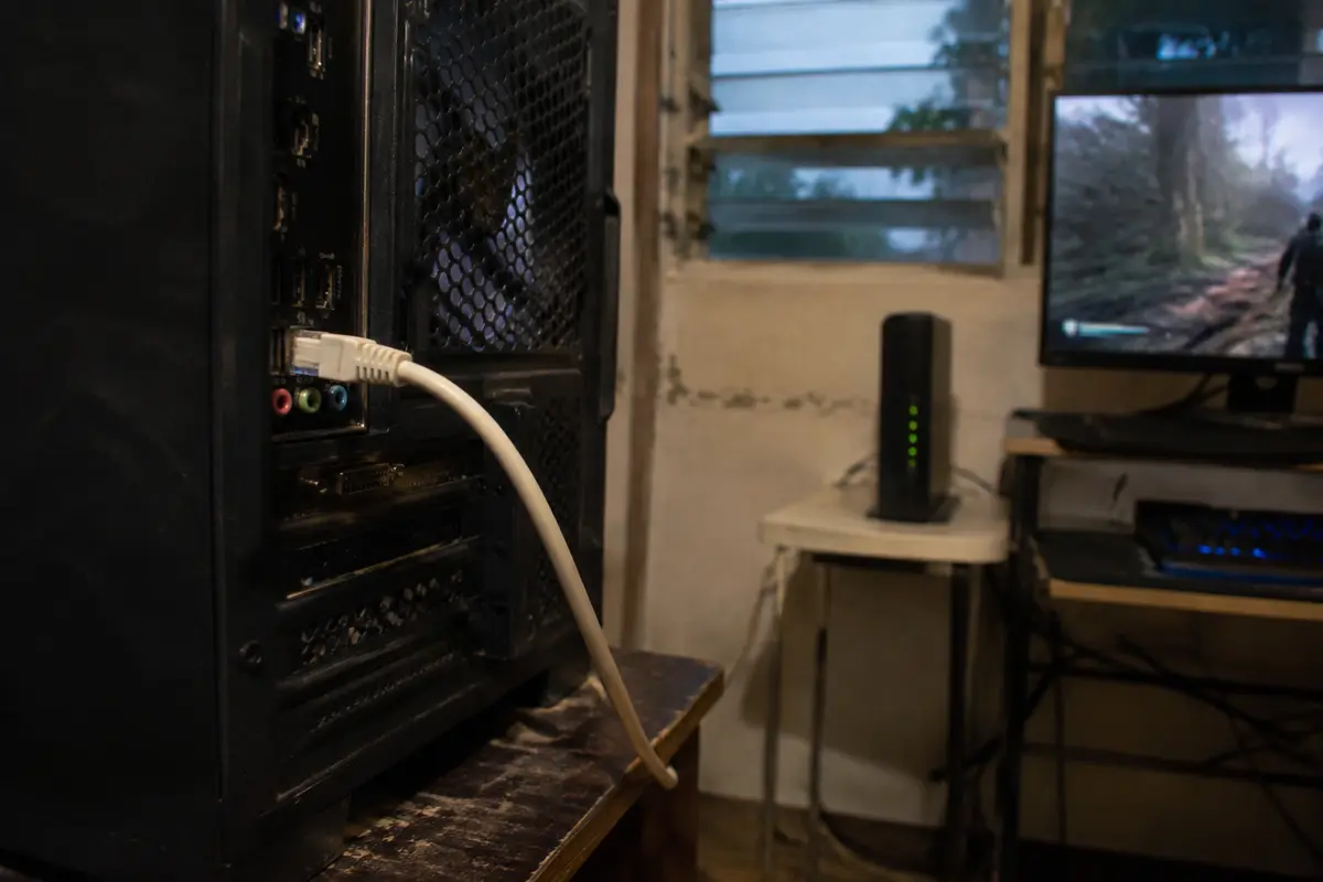 Un cable Ethernet conecta el PC de juego mientras el router permanece al fondo